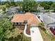 Aerial view of the property showcasing a well-manicured lawn, mature trees, and proximity to neighborhood amenities at 603 Ivey Ln, Tarpon Springs, FL 34689