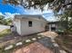 Exterior view of the home's backyard, featuring a pool, patio, and lush landscaping creating a private oasis at 603 Ivey Ln, Tarpon Springs, FL 34689