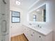 Modern bathroom featuring double sinks, an illuminated mirror, and a glass-enclosed shower at 603 Ivey Ln, Tarpon Springs, FL 34689