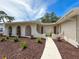 Stunning front yard featuring manicured landscaping, mature trees, and an inviting walkway at 603 Ivey Ln, Tarpon Springs, FL 34689