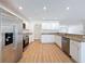 Bright kitchen featuring stainless steel appliances, granite countertops, and white cabinets at 603 Ivey Ln, Tarpon Springs, FL 34689