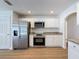 Modern kitchen featuring stainless steel appliances, granite countertops, and white cabinets at 603 Ivey Ln, Tarpon Springs, FL 34689
