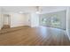 Spacious living room with wood-look flooring, ceiling fan, and large windows at 603 Ivey Ln, Tarpon Springs, FL 34689