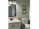 Cozy bathroom with vanity, a framed mirror, and a standard toilet with mint green walls at 6218 Palma Del Mar # 303, St Petersburg, FL 33715