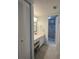 Hall bathroom with marble-look walk-in shower, tile floors, vanity, and closet storage at 6218 Palma Del Mar # 303, St Petersburg, FL 33715