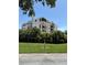 Exterior view of condo building surrounded by manicured landscaping and clear blue skies at 6218 Palma Del Mar # 303, St Petersburg, FL 33715