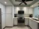 Modern kitchen featuring stainless steel appliances, white cabinets, and neutral countertops at 6218 Palma Del Mar # 303, St Petersburg, FL 33715