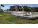 Community pool area with white fencing, lounge chairs, tropical landscaping, and beautiful surrounding buildings at 6218 Palma Del Mar # 303, St Petersburg, FL 33715