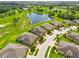 Scenic aerial view of homes near golf course and pond, showcasing lush landscaping and community charm at 644 Chipper Dr, Sun City Center, FL 33573