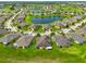 Community aerial shot with pond, green lawns, and houses in a circular neighborhood layout at 644 Chipper Dr, Sun City Center, FL 33573