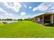Beautiful backyard with a screened in patio overlooking a well maintained lawn and lake at 644 Chipper Dr, Sun City Center, FL 33573