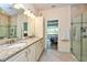 Bathroom with granite countertop, dual sinks, and glass shower at 644 Chipper Dr, Sun City Center, FL 33573