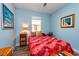 Cozy bedroom boasts natural light, beautiful artwork, and a comfortable bed with a colorful floral pattern at 644 Chipper Dr, Sun City Center, FL 33573
