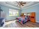 Bedroom with trey ceiling, ceiling fan, and natural light at 644 Chipper Dr, Sun City Center, FL 33573