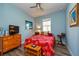 Bright bedroom featuring a ceiling fan, wood look floors, and a large window for ample natural light at 644 Chipper Dr, Sun City Center, FL 33573
