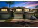 Exterior view of townhomes with garages and manicured lawns at sunset at 6677 84Th N Ave, Pinellas Park, FL 33781