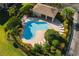 Aerial view of a community pool featuring lounge chairs, mature landscaping, and a covered pavilion for residents at 6677 84Th N Ave, Pinellas Park, FL 33781
