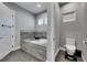 Bathroom featuring a bathtub with gray tiling, gray tile floor, and a toilet at 729 89Th N Ave, St Petersburg, FL 33702