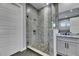 Bright bathroom with modern glass shower, pebble floor, and gray tiling at 729 89Th N Ave, St Petersburg, FL 33702