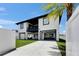 Modern two-story home showcasing an open carport, balcony, and well-maintained lawn at 729 89Th N Ave, St Petersburg, FL 33702