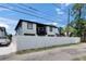 Modern two-story home featuring black trim, a white fence, and a lush, landscaped yard at 729 89Th N Ave, St Petersburg, FL 33702