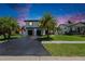 Inviting home exterior featuring a paved driveway, lush lawn, palm trees, and contemporary architectural design at 729 89Th N Ave, St Petersburg, FL 33702