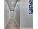 Long hallway with light gray walls, recessed lighting, and wood-look flooring at 729 89Th N Ave, St Petersburg, FL 33702