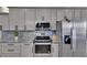 A well-equipped kitchen with stainless steel appliances, granite countertops, and gray cabinetry at 729 89Th N Ave, St Petersburg, FL 33702