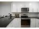 Close up of the kitchen area featuring a black countertop and stainless steel appliances at 801 83Rd N Ave # 412, St Petersburg, FL 33702
