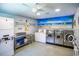 A well-lit community laundry room with modern washers and dryers, plus a folding table at 801 83Rd N Ave # 412, St Petersburg, FL 33702