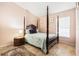 Comfortable bedroom with a four poster bed, accent rug, and a wooden night stand at 8104 Abbey Mist Cv, Tampa, FL 33619