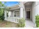 Inviting front porch with decorative columns, leading to the home's front door and windowed facade at 8104 Abbey Mist Cv, Tampa, FL 33619