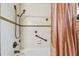 Clean bathroom with white tile, a shower head, grab bar, and a patterned shower curtain at 9548 141St St, Seminole, FL 33776