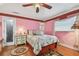 Comfortable bedroom featuring pink walls, hardwood floors, and a decorative ceiling fan at 9548 141St St, Seminole, FL 33776