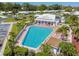 Aerial view of a community pool with lounge chairs and lush tropical landscaping at 9548 141St St, Seminole, FL 33776