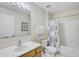 Bathroom with a single sink vanity, toilet, and shower-tub combo with curtain at 10437 River Bream Dr, Riverview, FL 33569