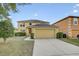 Two-story home featuring a two-car garage, well-maintained lawn, and manicured shrubbery at 10437 River Bream Dr, Riverview, FL 33569