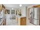 Charming kitchen with island, stainless steel refrigerator, and arches leading to the dining area at 10437 River Bream Dr, Riverview, FL 33569