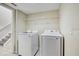 Convenient laundry area with modern washer and dryer units and overhead wire shelving at 10437 River Bream Dr, Riverview, FL 33569