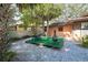 Backyard area featuring table, chairs, fire pit, and tropical landscaping at 10729 Drummond Rd, Tampa, FL 33615