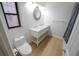 Bright bathroom featuring a marble countertop vanity, decorative mirror, and wood-look floors at 10729 Drummond Rd, Tampa, FL 33615