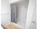 Bright bathroom featuring a shower with white tiling and a gray patterned shower curtain at 10729 Drummond Rd, Tampa, FL 33615