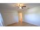 Bedroom with wood flooring, ceiling fan, and white bi-fold closet doors at 10729 Drummond Rd, Tampa, FL 33615