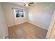 Cozy bedroom featuring wood floors, a ceiling fan, and a bright window at 10729 Drummond Rd, Tampa, FL 33615