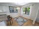 Bright dining area with modern light fixture, large window, and a gray patterned rug on wood-look floors at 10729 Drummond Rd, Tampa, FL 33615