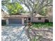 Charming home with a mature tree in the front yard and a spacious driveway leading to an attached garage at 10729 Drummond Rd, Tampa, FL 33615