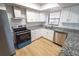Updated kitchen featuring stainless steel appliances, granite countertops, and sleek white cabinetry at 10729 Drummond Rd, Tampa, FL 33615