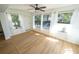 Inviting living room featuring light wood floors, many windows and a white entry door at 10729 Drummond Rd, Tampa, FL 33615
