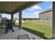 A covered patio showcasing a spacious backyard, well-maintained lawn, and privacy fence at 11002 Sundrift Dr, Tampa, FL 33647