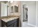Bathroom vanity with a decorative granite countertop, dark wood cabinets and an archway to another room at 11002 Sundrift Dr, Tampa, FL 33647